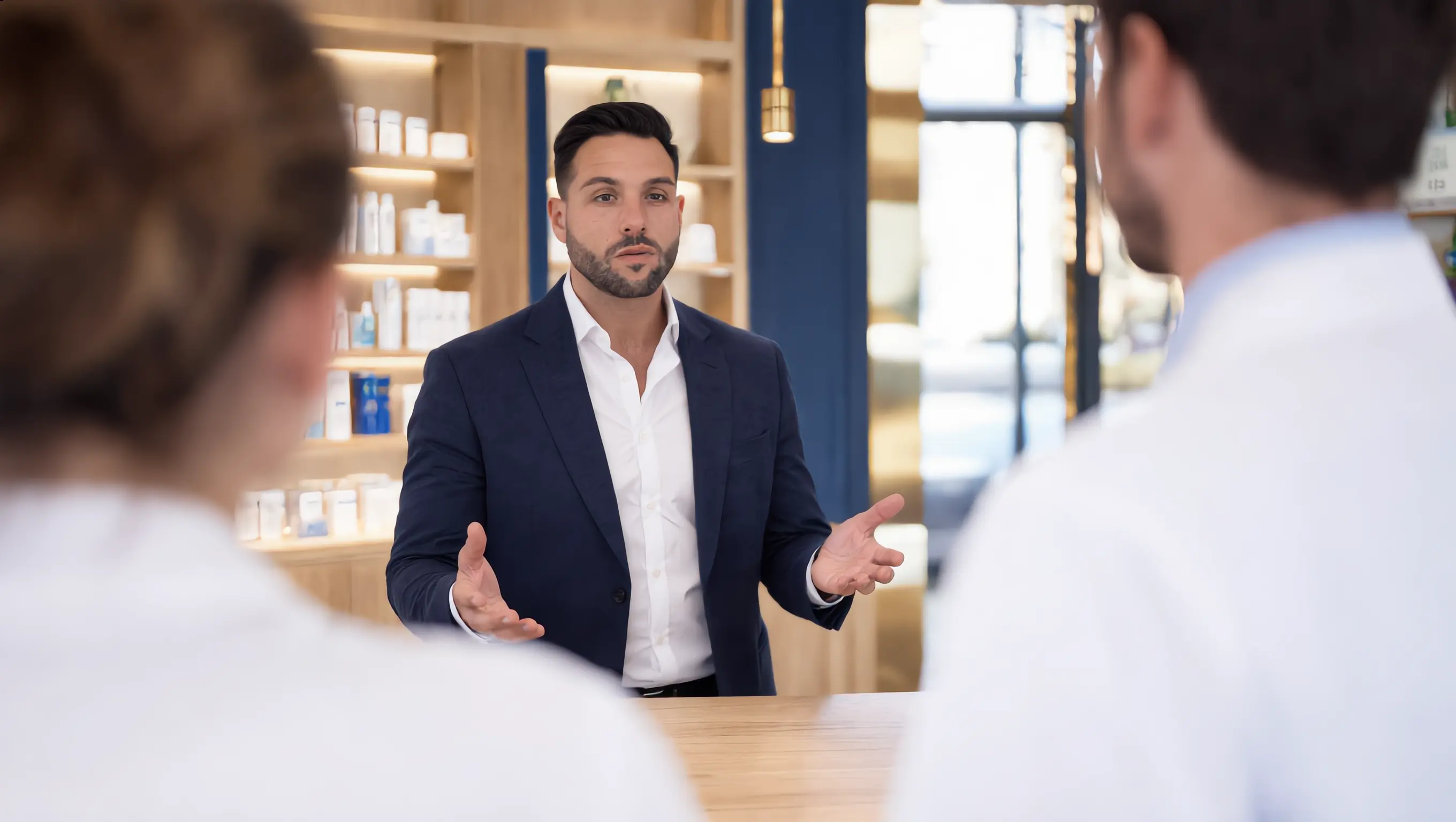 Benjamin Herisson anime une formation face à une équipe de pharmaciens, au comptoir d’une officine